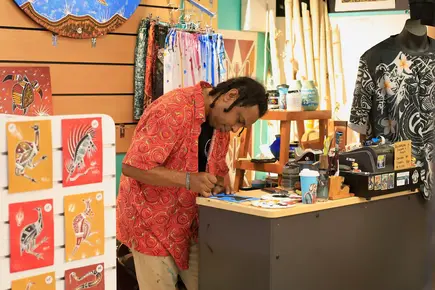 man leaning over counter in craft shop